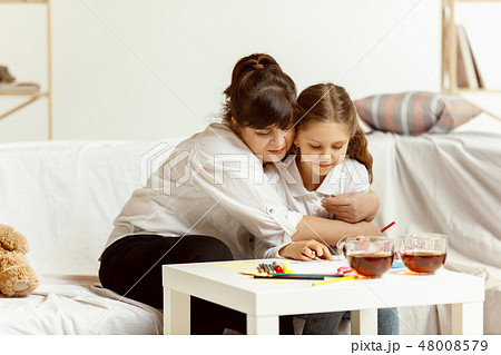 Little girl and charming grandmother are sitting at home 48008579