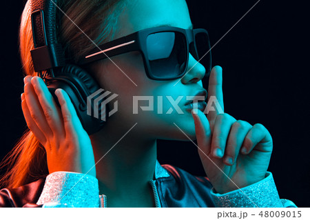 Young girl with headphones enjoying music 48009015