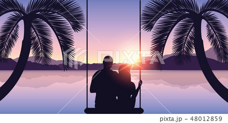 couple in love on a swing enjoys the sunset on the beach 48012859