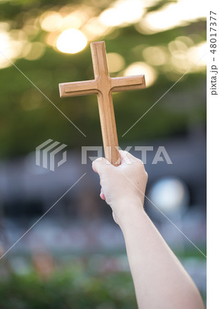 Person palm hands to hold holy cross, 48017377