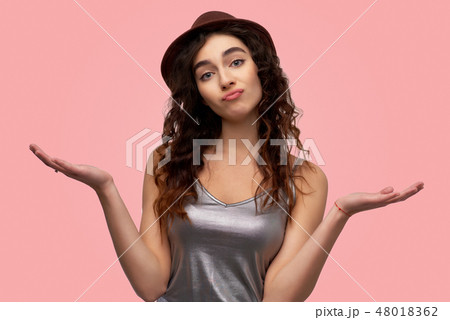 Hesitant young woman purses lower lip 48018362