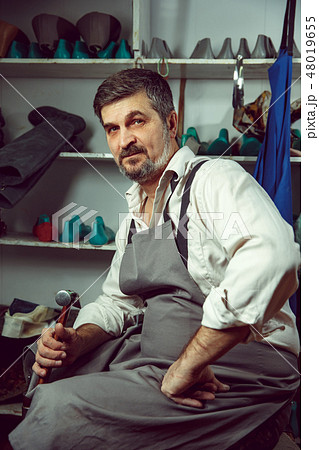 Enjoying process of creation custom made shoes. Workplace of shoe designer 48019655