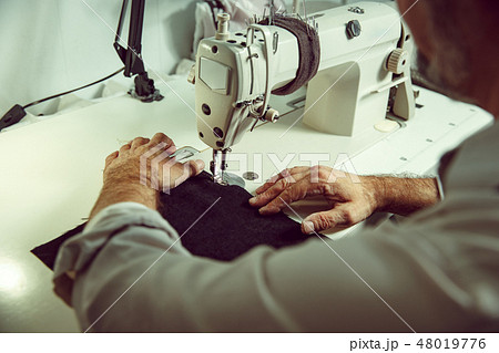 Sewing process of the leather belt. old Man's hands behind sewing. Sewing process of the leather belt. old Man's hands behind sewing. 48019776