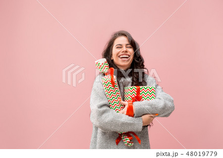 Woman with big beautiful smile holding colorful gift boxes. 48019779