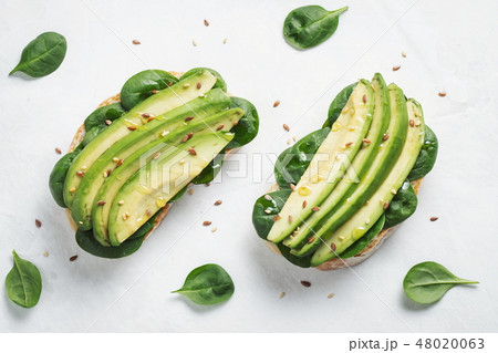 Two ciabatta toast with sliced avocado. Two ciabatta toast with sliced avocado. 48020063