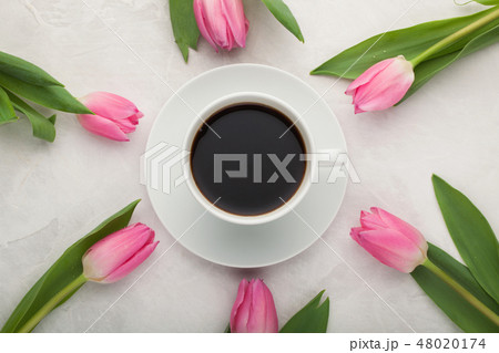 Black coffee in white Cup and tulips. Black coffee in white Cup and tulips. 48020174