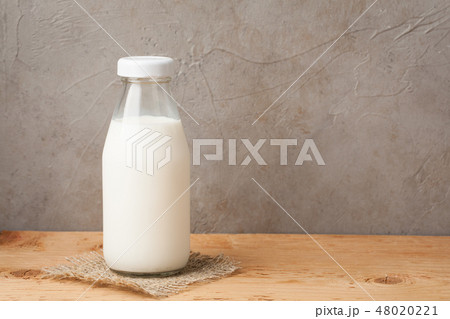 Bottle of milk on a wooden table. 48020221