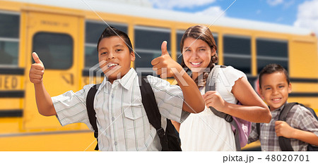 Young Hispanic Boys and Girl Walking by School Bus Young Hispanic Boys and Girl Walking by School Bus 48020701