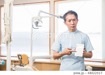 電卓を指差す歯医者さん 48022017
