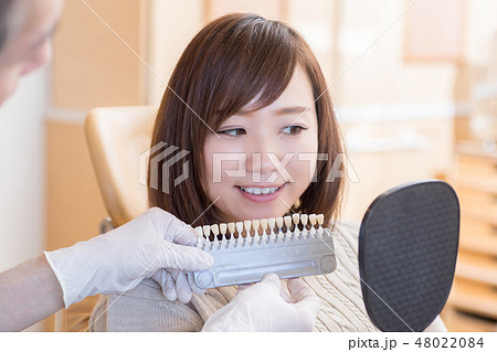 歯の色見本を見る女性 48022084