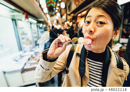 backpacker eating delicious colorful rice ball 48022118