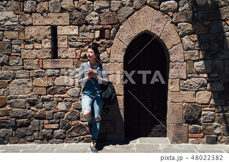 girl relying on wall of ancient medieval castle girl relying on wall of ancient medieval castle 48022382