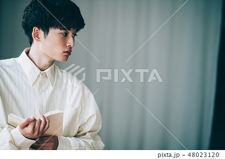 窓際で本を読む白いシャツの男性 窓際で本を読む白いシャツの男性 48023120