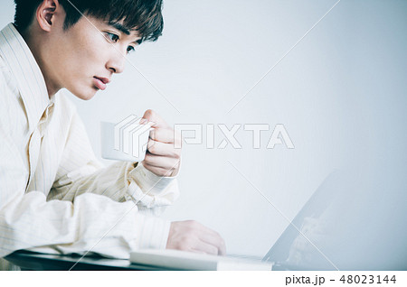 椅子に座ってノートパソコンに向かう男性 48023144