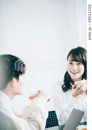 休憩室でマグカップを手に談笑する男女 休憩室でマグカップを手に談笑する男女 48023169