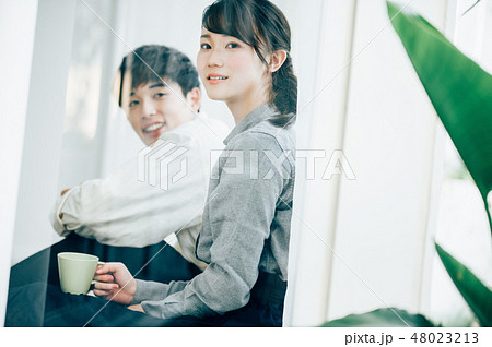 窓際に座って談笑する男女 窓際に座って談笑する男女 48023213