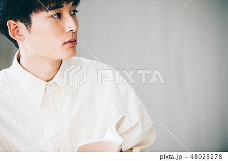 窓際で本を読む白いシャツの男性 窓際で本を読む白いシャツの男性 48023278