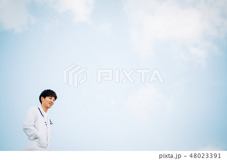 屋上に立つ白衣を着た男性 48023391