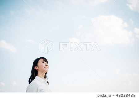 屋上に立つ白いシャツを着た女性 48023438