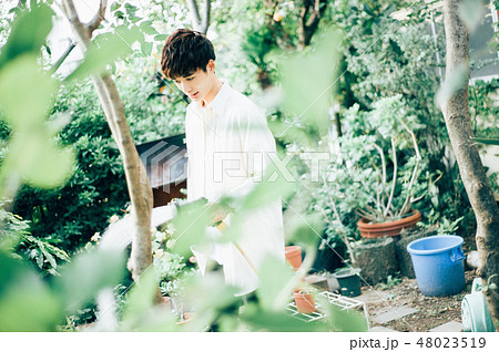 庭で水をまく男性 48023519