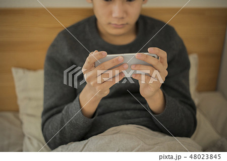 ベッドでスマートフォンを使う男の子 寝不足 中学生 高校生 ボディパーツ パーツカット 顔なし ベッドでスマートフォンを使う男の子 寝不足 中学生 高校生 ボディパーツ パーツカット 顔なし 48023845