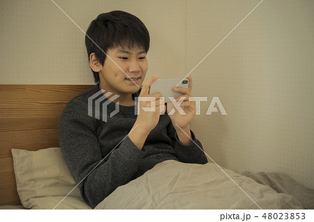 ベッドでスマートフォンを使う男の子　寝不足　中学生　高校生 48023853
