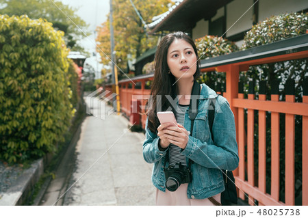 Positive asian girl traveler using smartphone 48025738