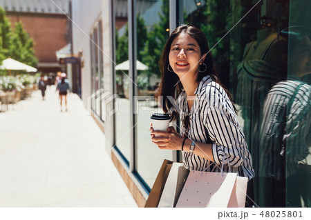 charming girl smiling standing against window 48025801