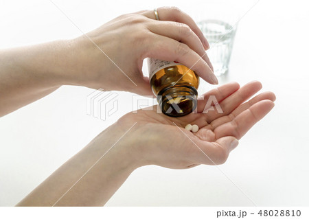 薬の瓶を左手で持ち上げて右手の手のひらに錠剤の薬を出すまでの一連の動作 白背景の写真素材 薬の瓶を左手で持ち上げて右手の手のひらに錠剤の薬を出すまでの一連の動作 白背景の写真素材
