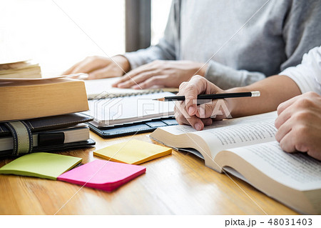 High school tutor or college student group sitting at desk in li 48031403