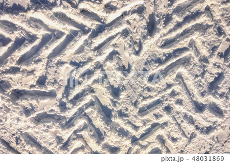Vehicle and tractor tire tread imprints on snow 48031869