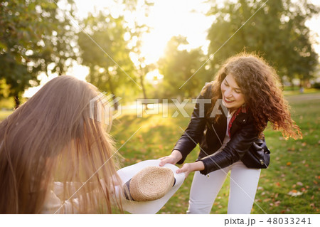 Outdoors portrait of two merry young woman.  48033241