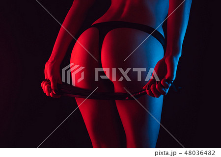 Sexy erotic ass of a girl in a Thong with a whip for BDSM 48036482