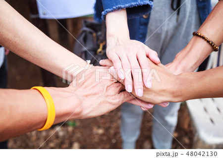 men and women stacking hands in meeting background men and women stacking hands in meeting background 48042130