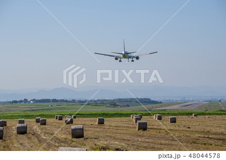旭川空港の航空機と牧草地の牧草ロール 48044578