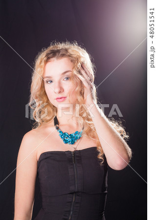 Fashion and model concept - Portrait of beautiful young sexy blond woman in a black dress posing Fashion and model concept - Portrait of beautiful young sexy blond woman in a black dress posing 48051541