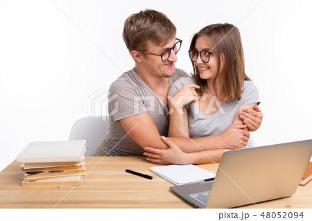 Education, people and relationship concept - a couple of students is hugging, because they are tired Education, people and relationship concept - a couple of students is hugging, because they are tired 48052094