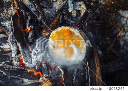 Fried eggs on the pan on the fire in winter Fried eggs on the pan on the fire in winter 48053265