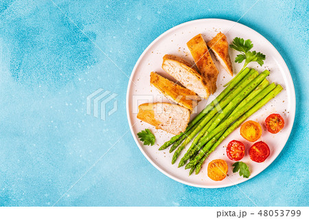 Roasted chicken breast with asparagus tomatoes. 48053799