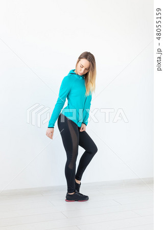 People, sport and fitness concept - attractive young woman in sportswear posing on white background 48055159