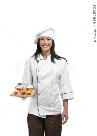 Young confectioner in uniform holding tray with sweets. Young confectioner in uniform holding tray with sweets. 48060403