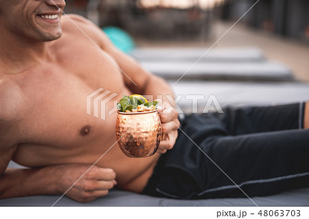 Shirtless man smiling and enjoying delicious drink in the cup Shirtless man smiling and enjoying delicious drink in the cup 48063703