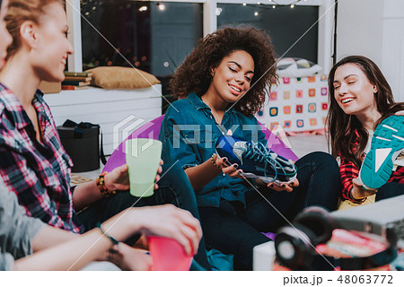 Woman looking at sporting footwear at meeting with friends 48063772
