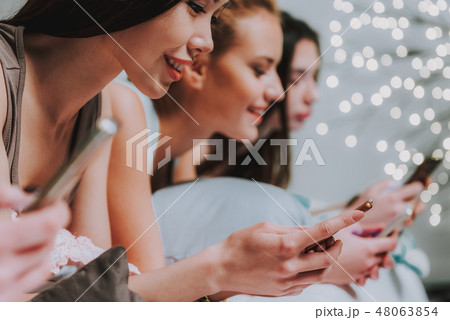 Cheerful girls browsing social networks in bed Cheerful girls browsing social networks in bed 48063854