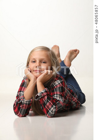 Girl with long blond hair is lying on the floor. White background 48065857