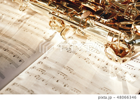 Time for jazz. Close up image of a shiny keys of golden saxophone lying on the sheet of music 48066346