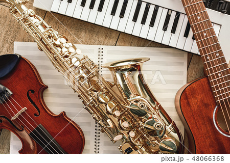 Power of music. Top view of musical instruments set: synthesizer, guitar, saxophone and violin lying 48066368