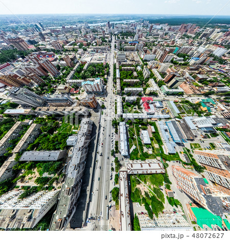 Aerial city view with crossroads and roads, houses, buildings, parks and parking lots. Sunny summer 48072627