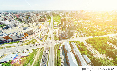 Aerial city view with crossroads and roads, houses, buildings, parks and parking lots. Sunny summer 48072632