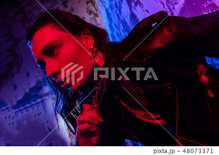 Beautiful young woman touching her massive necklace Beautiful young woman touching her massive necklace 48073371